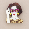 Broche de pasta multicolores de chica cogiendo las gafas. Pelo marrón