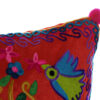 Cojin y funda multicolor con árbol y pájaro. Detalle del bordado en el cojin rojo