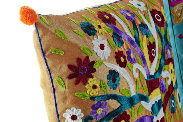 Cojin y funda multicolor con árbol y montaña. Detalle del bordado y la borla