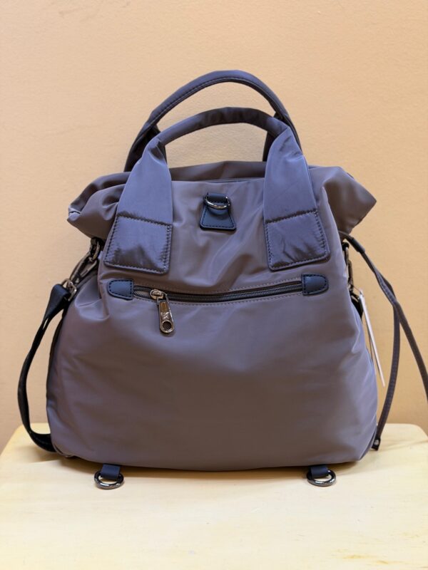 Parte posterior de la de color taupe. Se aprecian los anclajes que sirven para hacerla mochila con las dos asas extensibles que trae