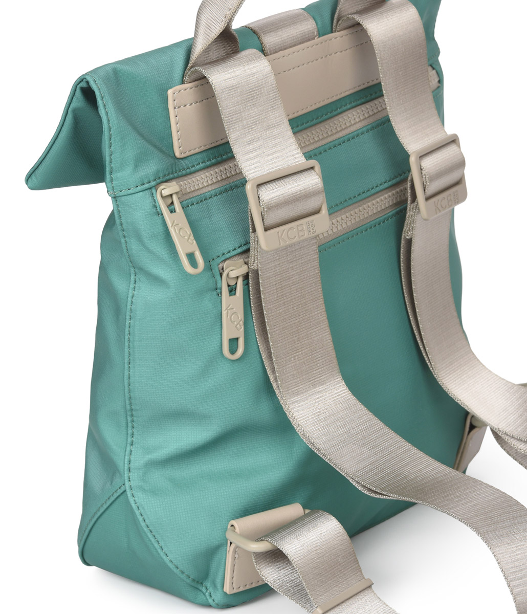 Vista posterior de la color verde. Se aprecia el acceso a la mochila y un bolsillo exterior